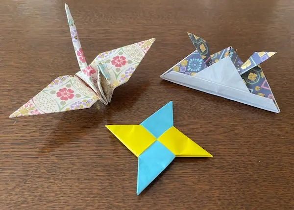 "Origami crane (つる, orizuru), samurai helmet (かぶと, kabuto), and ninja star (しゅりけん, shuriken) made from colorful washi paper"