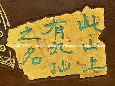The green verdigris Regular Script "此山上有九仙之名" is carved against a gold leaf background.